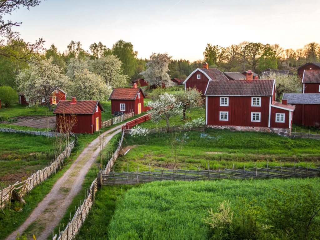 Röda hus med vita knutar i kulturreservatet Stensjö by.