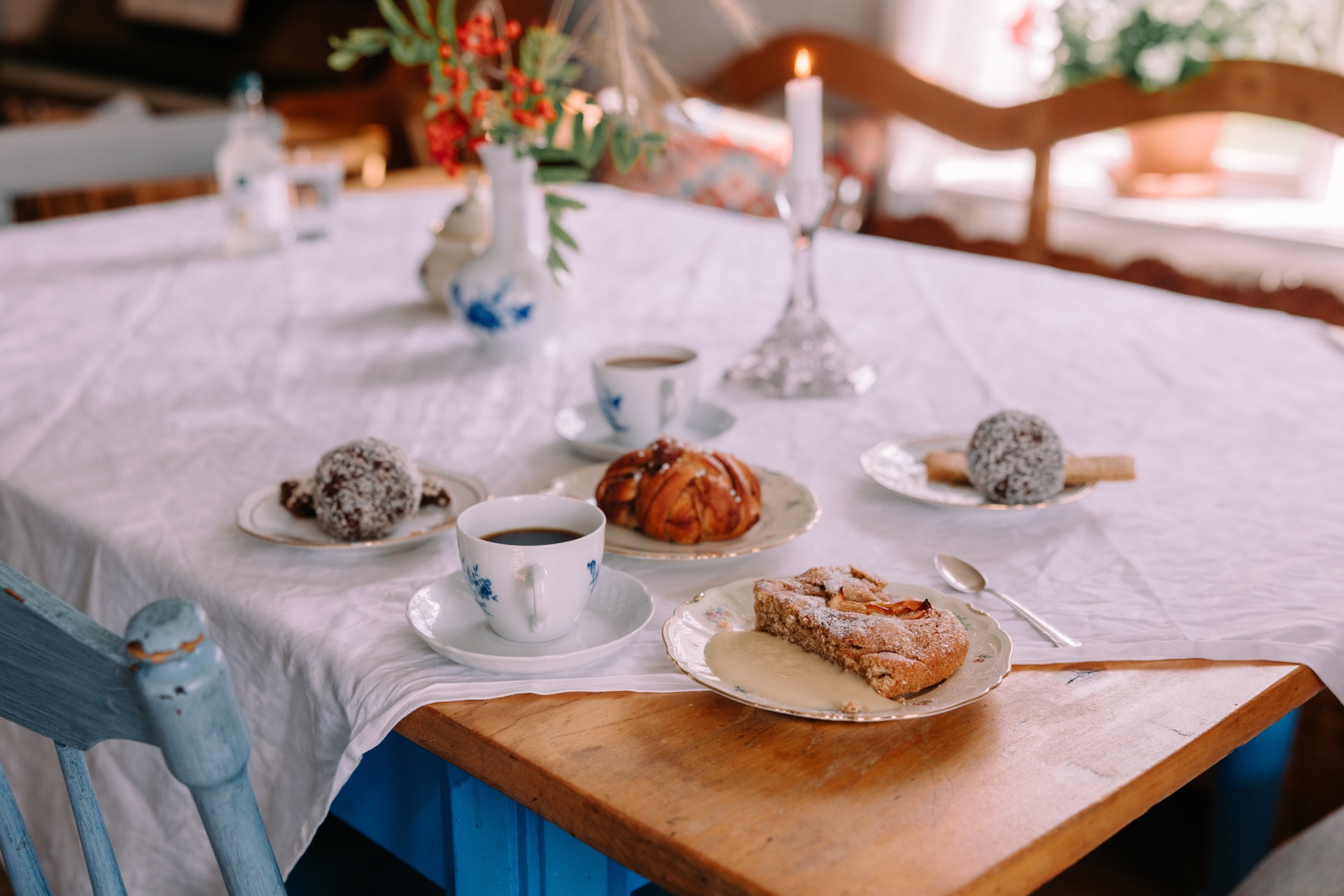 Bild på kaffe och fika uppdukat på ett bord med duk på Tilias kafé i Stensjö by.