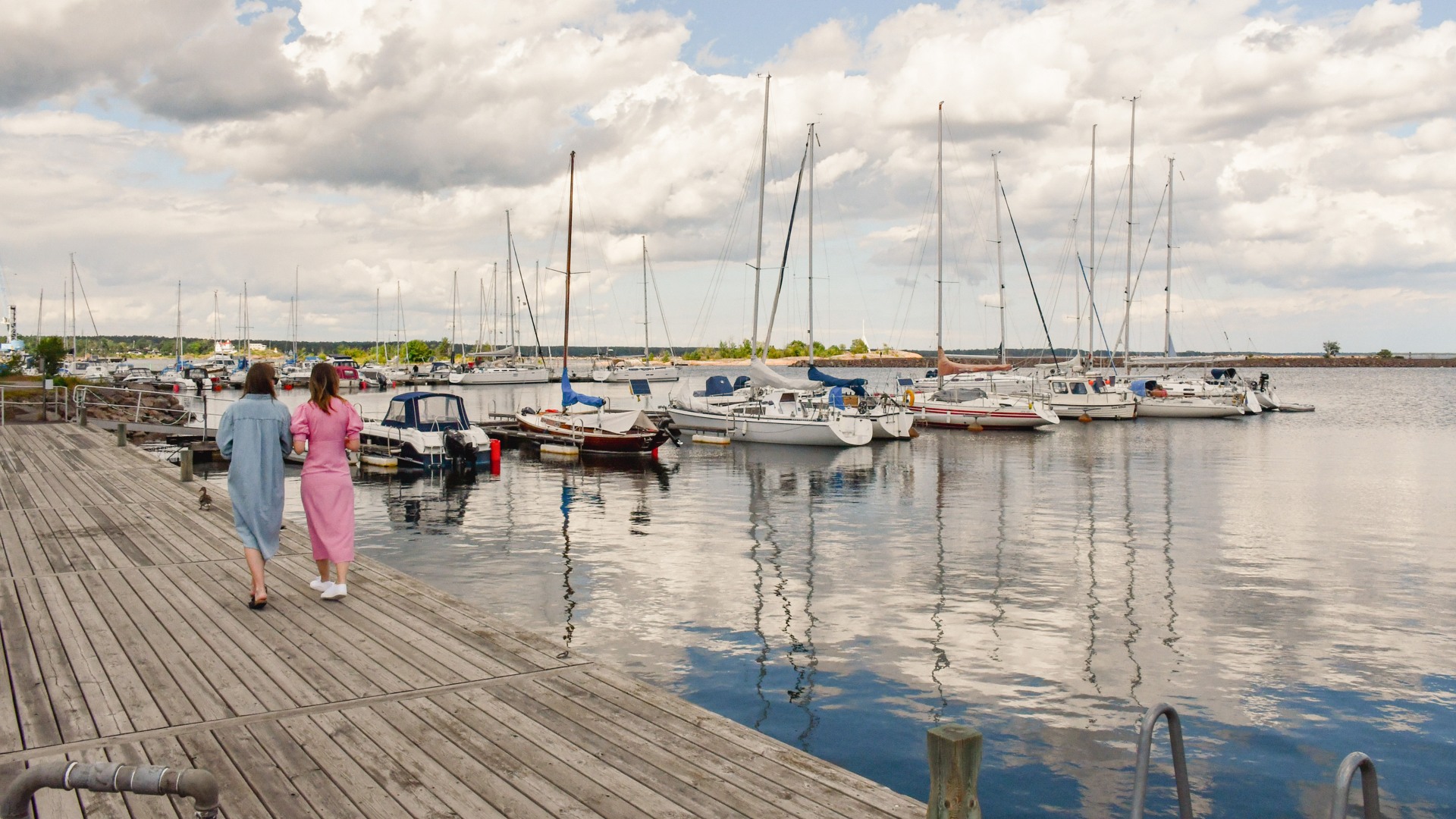 Två personer som går på bryggan vid Ernemars gästhamn i Oskarshamn.