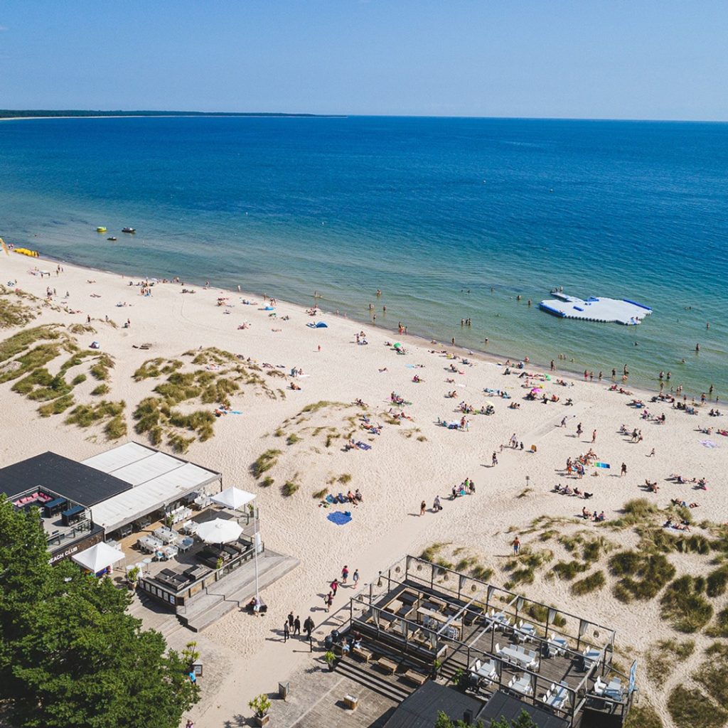 Böda sand, en stor vit sandstrand på Ölands kust med många badgäster vid det blå havet.