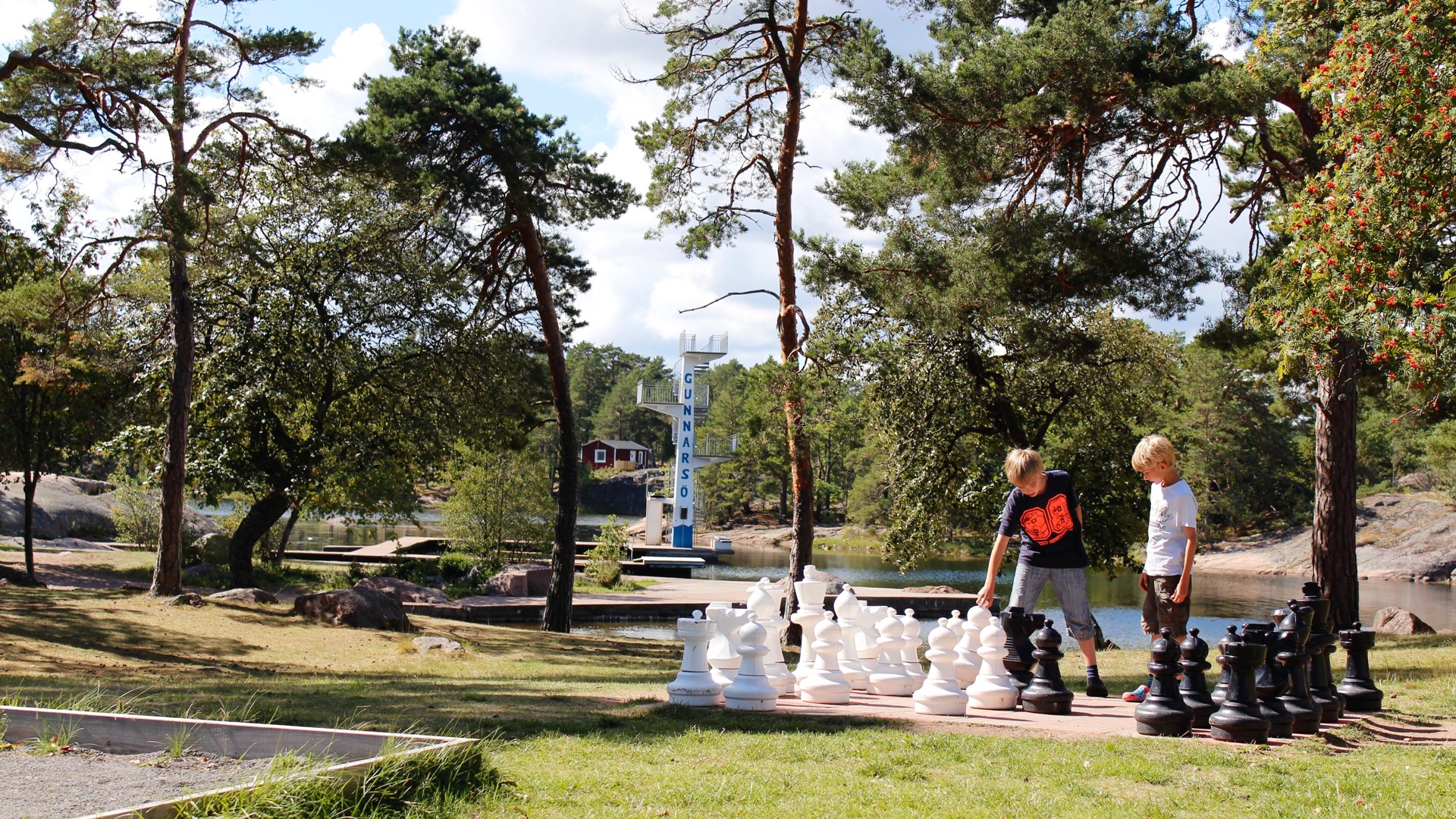 Två barn som spelar schack utomhus på First Camp Gunnarsö.