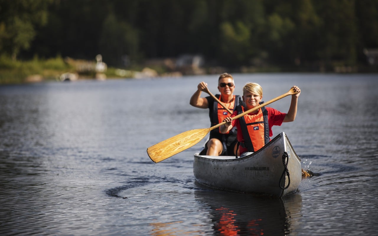 Två personer som paddlar kanot i en sjö i Oskarshamn.