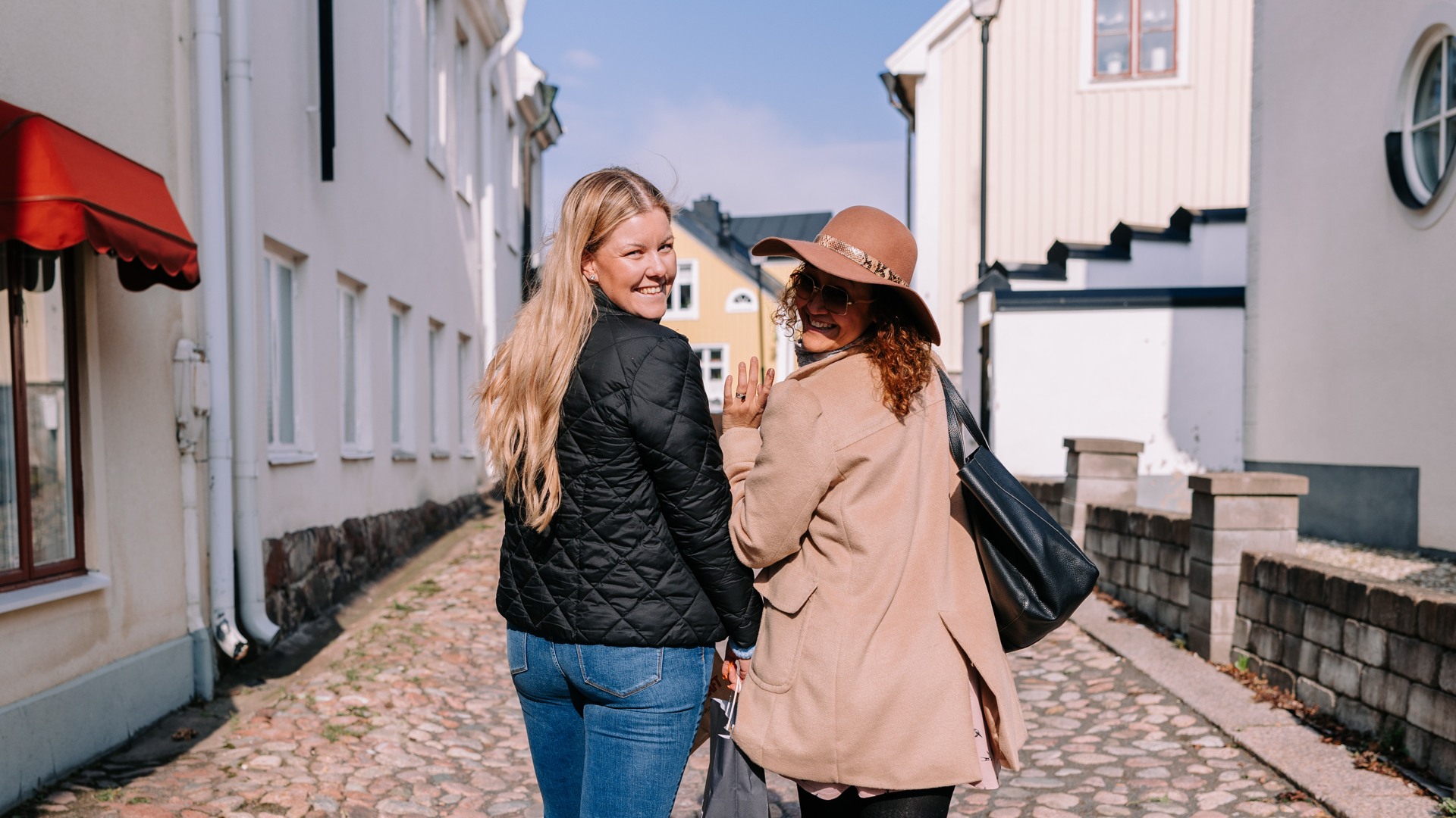 Två personer som strosar och shoppar i Oskarshamns stadskärna.