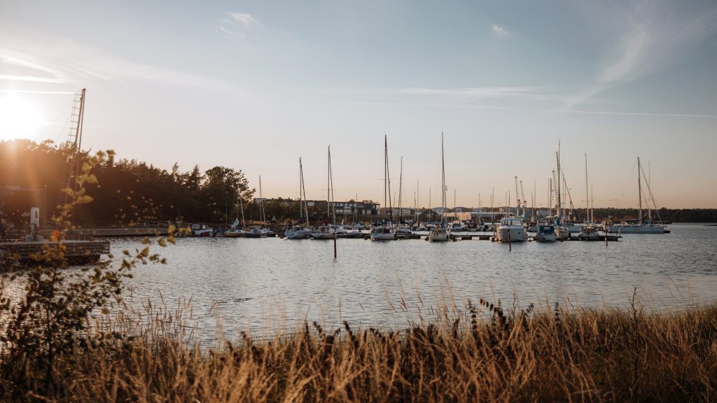 Gästhamn i Oskarshamn i kvällsljuset med segel och motorbåtar.