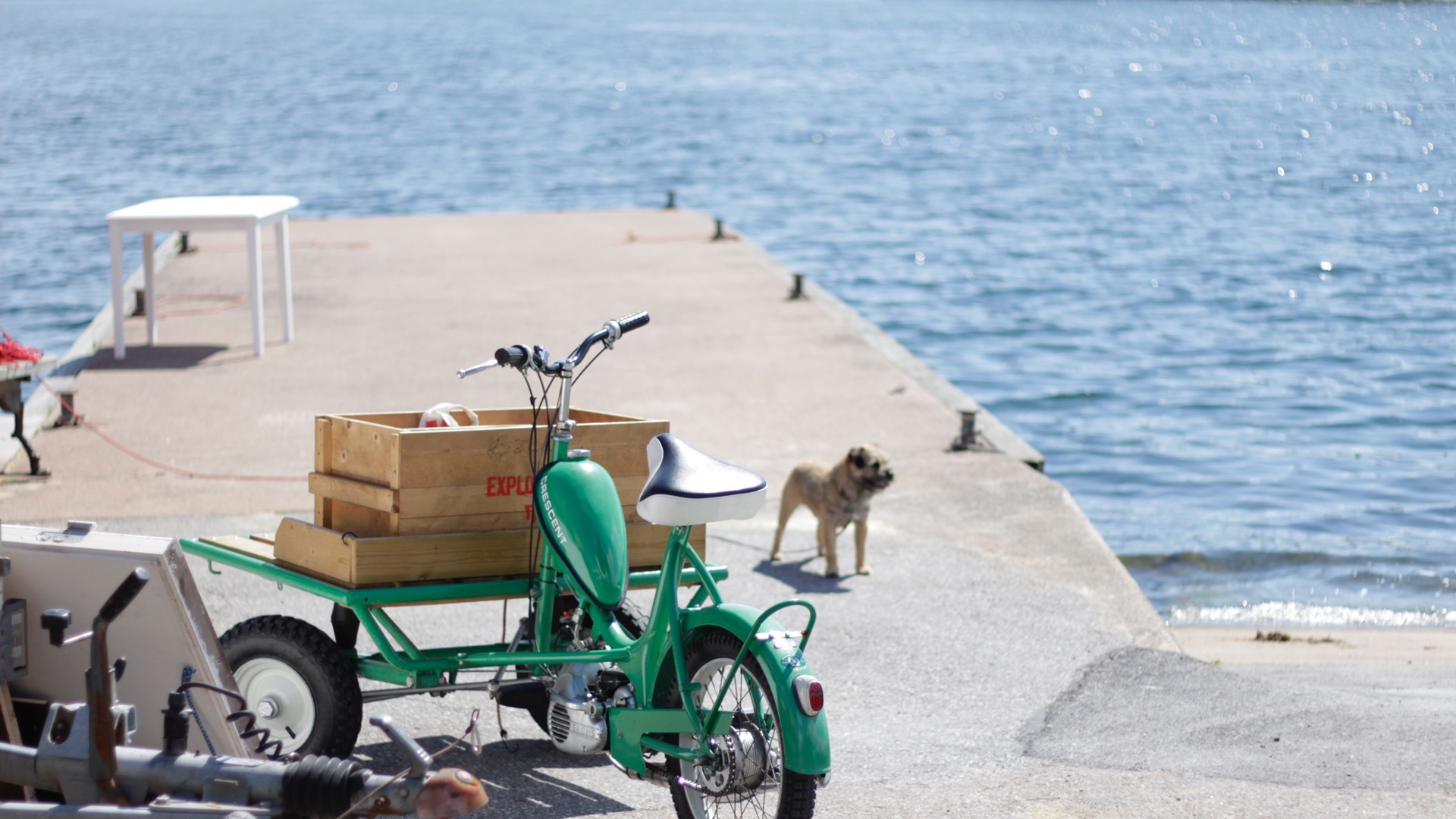 Bild på en grön cykelmoppe med låda på en brygga vid havet vid Valborgs i Klintemåla