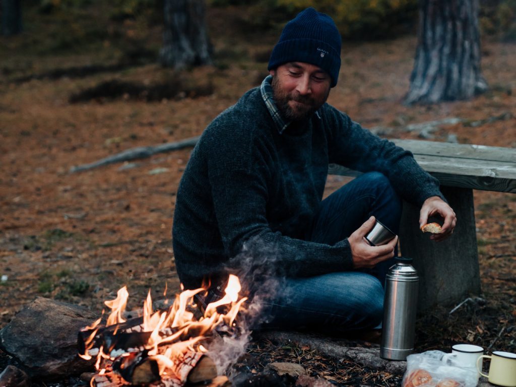 Person vid grillplats med öppen eld utomhus
