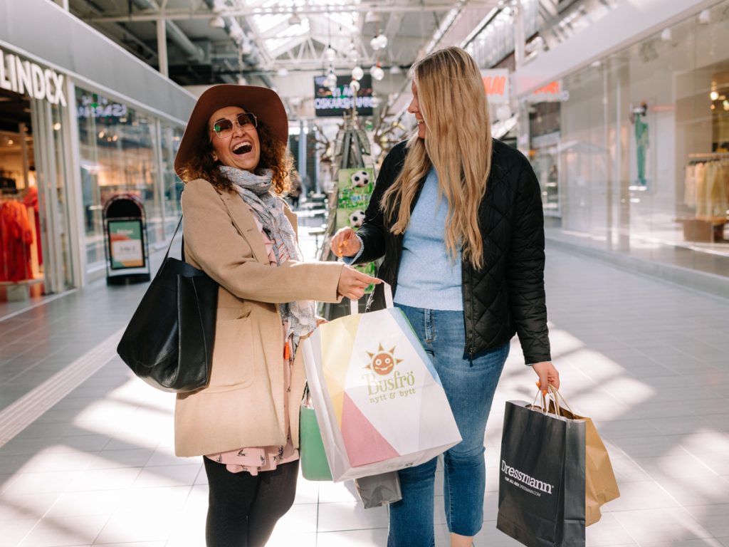 Två personer med shoppingkassar i Oskarshamns centrum.