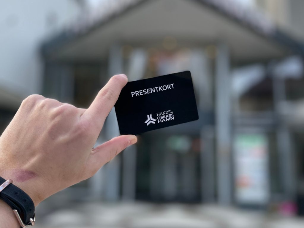 Bild på en hand som håller i ett presentkort i Handel Oskarshamn