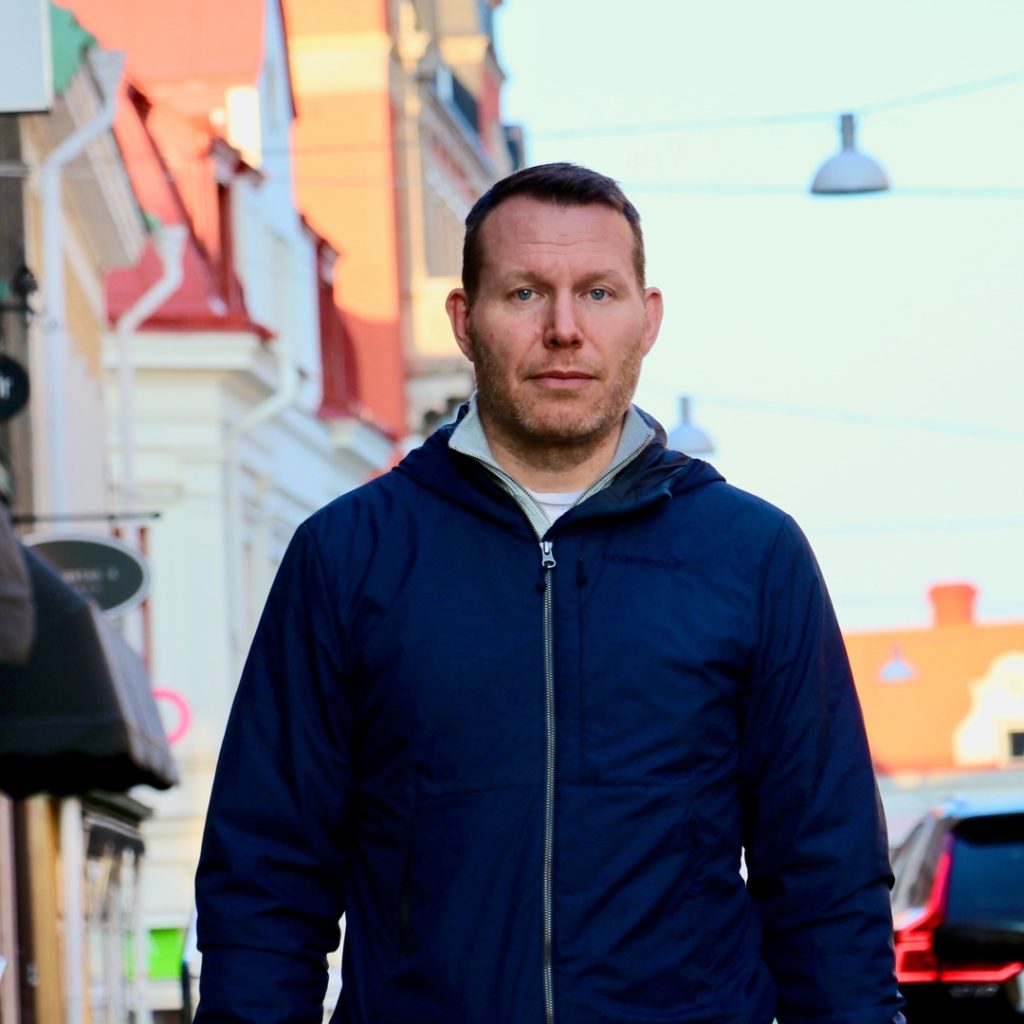 Kristoffer Malm går ner för Oskarshamns gator iklädd blå jacka.