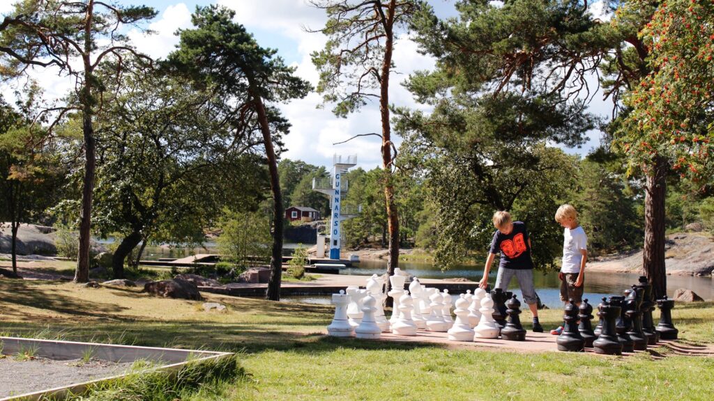 Barn som spelar schack utomhus på First Camp Gunnarsö.